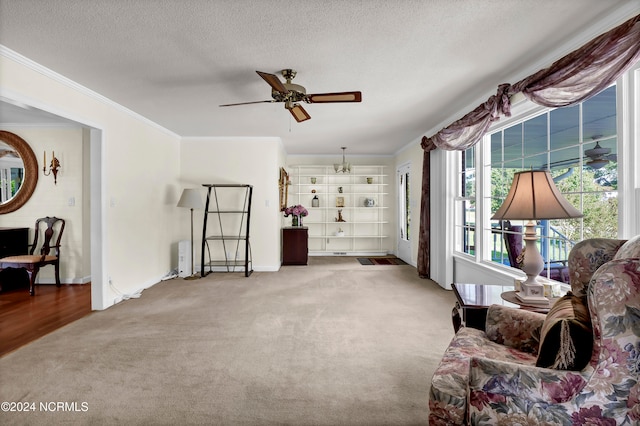 living room with ornamental molding, carpet, a textured ceiling, and ceiling fan