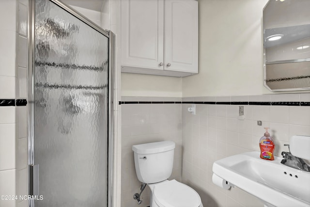 bathroom with tile walls, sink, toilet, and walk in shower