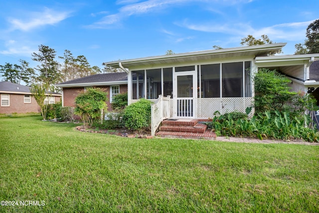 back of house with a lawn and a sunroom