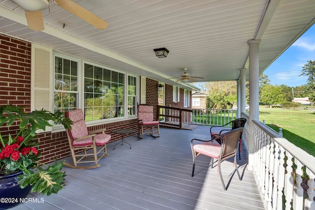 deck featuring a porch, a lawn, and ceiling fan