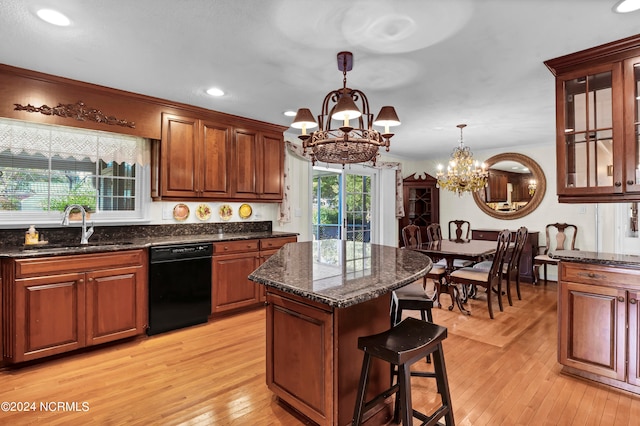 kitchen with a kitchen island, dishwasher, hanging light fixtures, sink, and light hardwood / wood-style floors