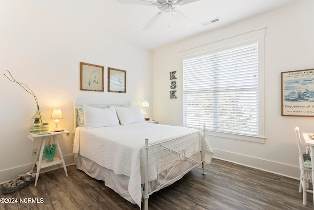 bedroom with a ceiling fan, wood finished floors, visible vents, and baseboards