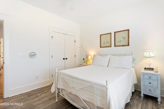 bedroom with a closet, baseboards, wood finished floors, and a ceiling fan