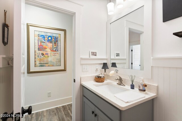 bathroom with baseboards, wood finished floors, and vanity