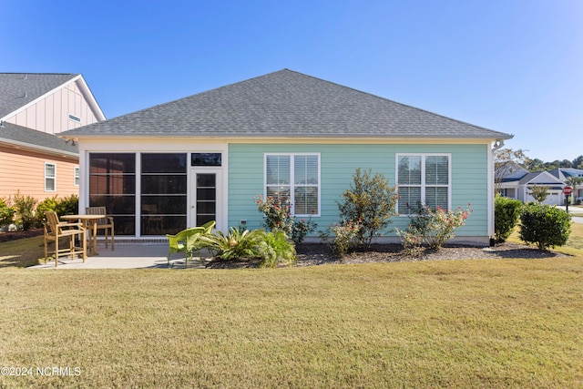 rear view of property with a patio, a lawn, and a shingled roof