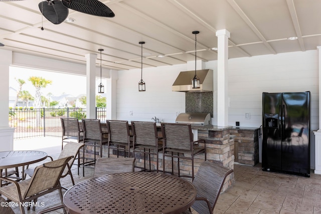 view of patio featuring outdoor dining space, fence, exterior kitchen, outdoor wet bar, and a grill