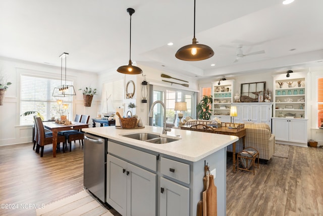 living room with light wood-type flooring, a tray ceiling, and ceiling fan