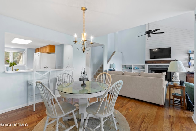 dining space with light hardwood / wood-style flooring and ceiling fan with notable chandelier