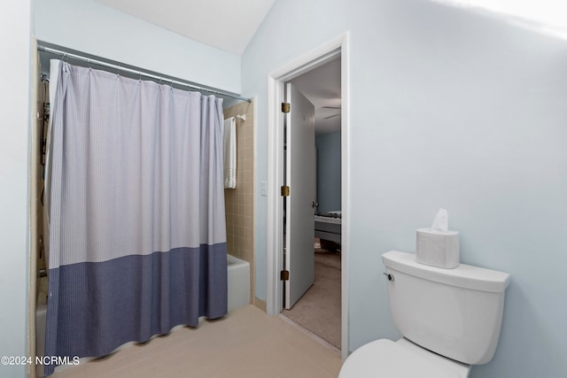 bathroom with toilet, lofted ceiling, shower / bath combination with curtain, and tile patterned flooring