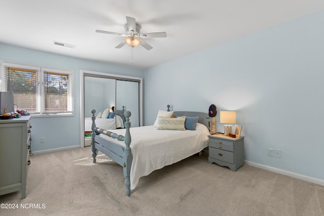 bedroom with a closet, light colored carpet, and ceiling fan