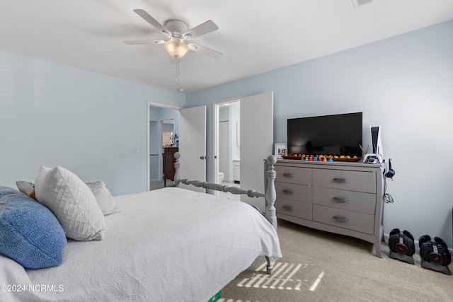 carpeted bedroom with ensuite bathroom and ceiling fan