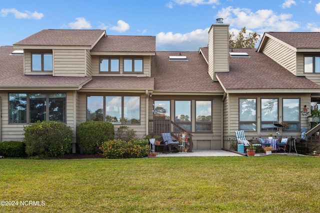 rear view of property featuring a patio area and a lawn