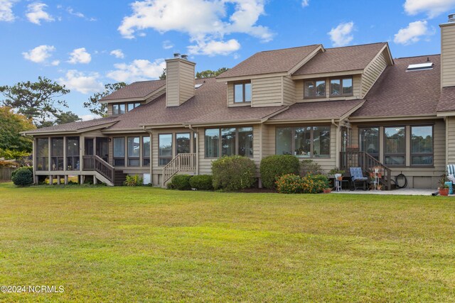 rear view of property with a patio, a sunroom, and a lawn