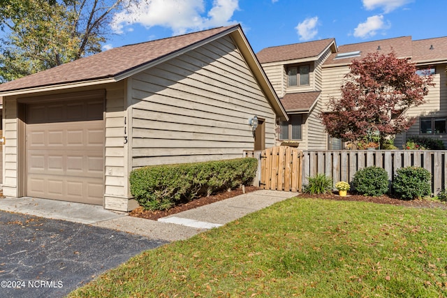 view of property exterior with a garage and a lawn