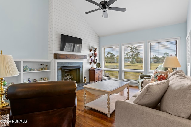 living room with a fireplace, hardwood / wood-style flooring, high vaulted ceiling, and ceiling fan