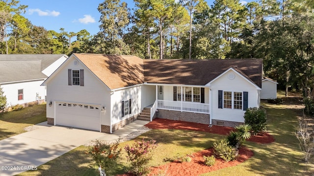 view of front facade featuring a porch, a front lawn, and a garage