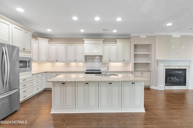 kitchen with sink, appliances with stainless steel finishes, a kitchen island with sink, and dark hardwood / wood-style flooring