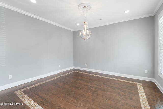 empty room featuring ornamental molding, an inviting chandelier, and dark hardwood / wood-style floors