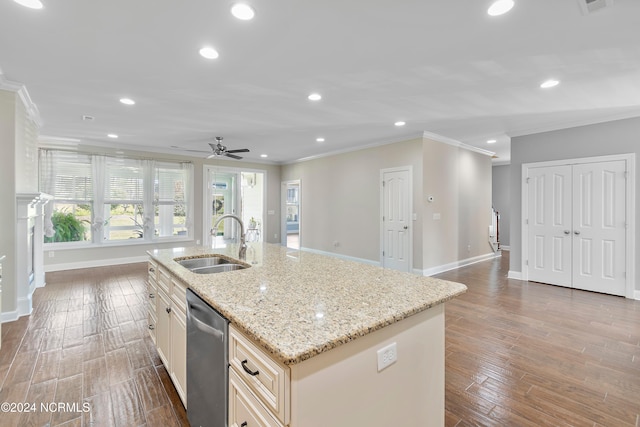 kitchen featuring a center island with sink, stainless steel dishwasher, wood-type flooring, ornamental molding, and sink