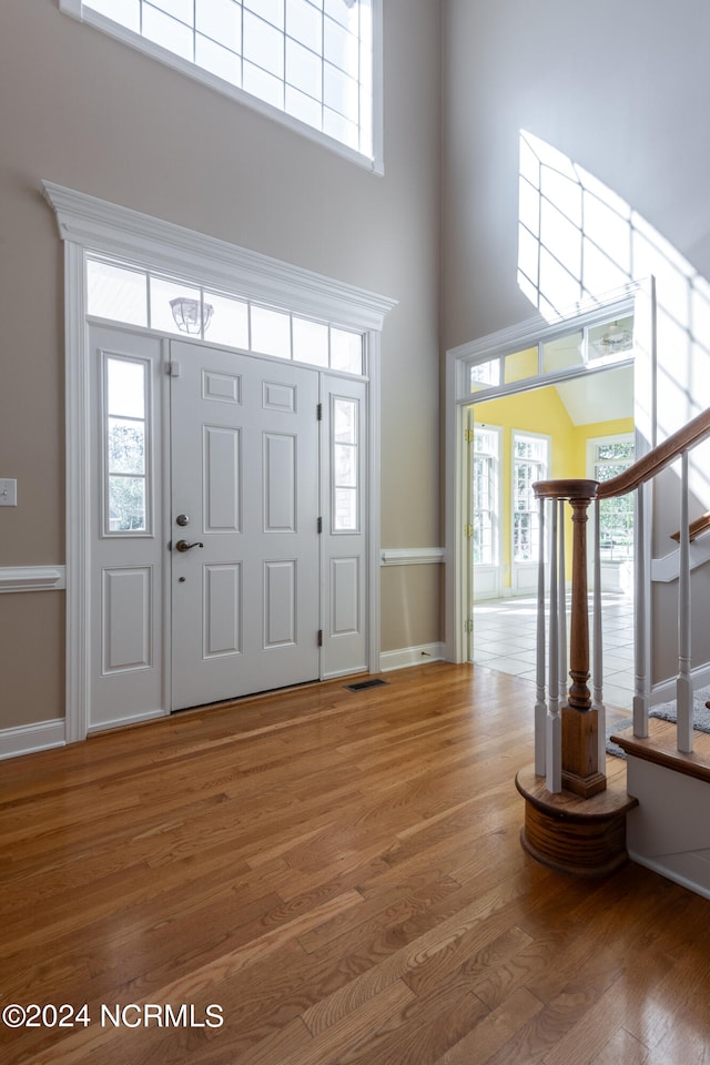 entrance foyer with a towering ceiling and hardwood / wood-style floors