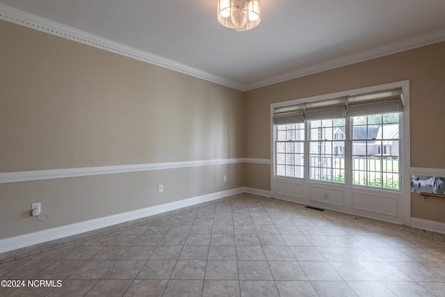 tiled empty room featuring ornamental molding