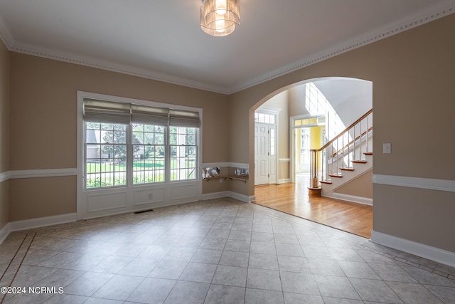 tiled spare room with crown molding