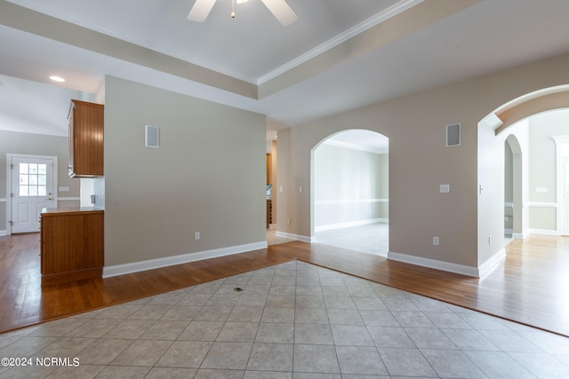 unfurnished room featuring ornamental molding, light wood-type flooring, and ceiling fan