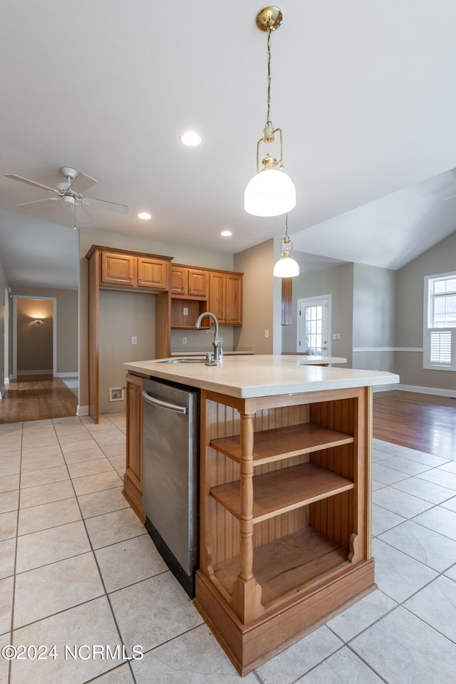 kitchen featuring light tile patterned floors, dishwasher, an island with sink, and decorative light fixtures