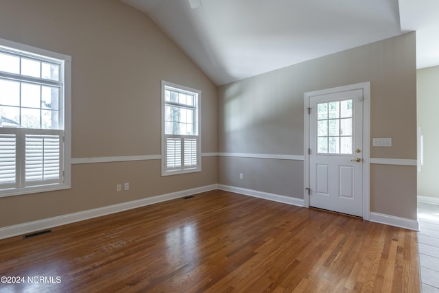 entrance foyer featuring lofted ceiling, wood finished floors, visible vents, and baseboards