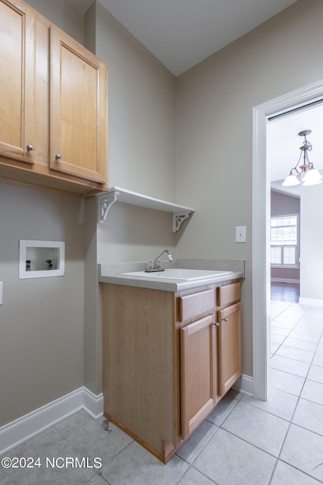 washroom featuring cabinets, light tile patterned floors, a chandelier, hookup for a washing machine, and sink