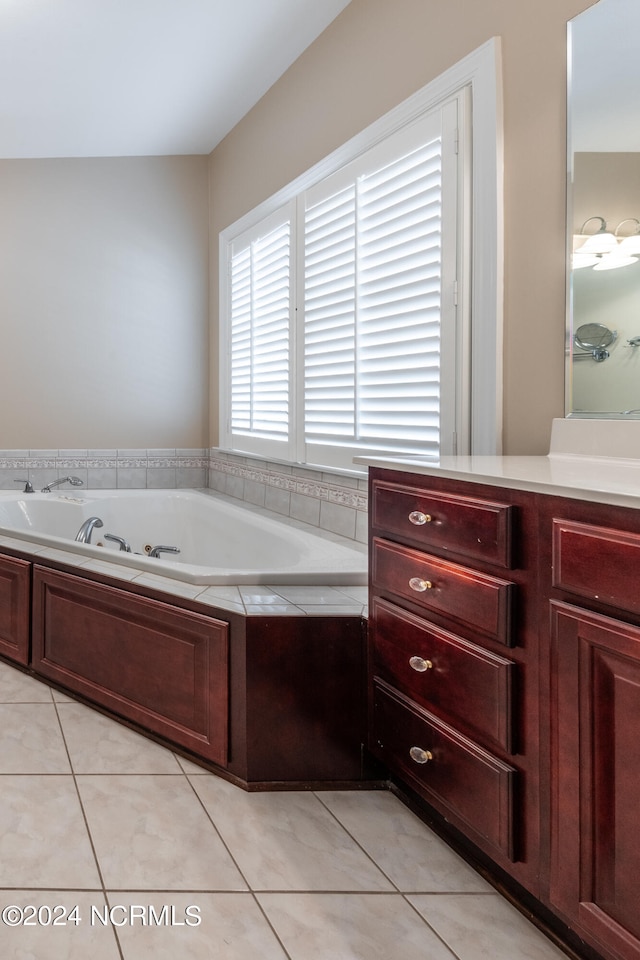 bathroom featuring vanity, a relaxing tiled tub, and tile patterned floors