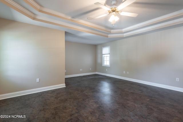 carpeted empty room featuring ornamental molding, a tray ceiling, and ceiling fan