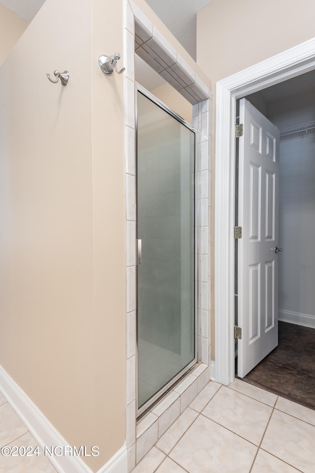 bathroom featuring a shower with door and tile patterned flooring