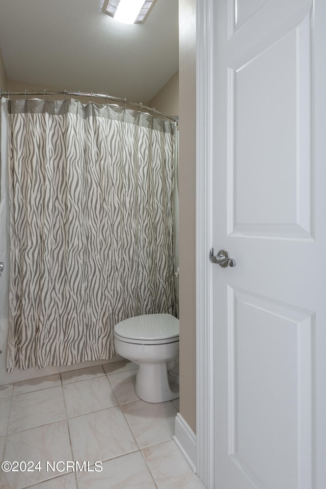 bathroom with a shower with shower curtain and toilet