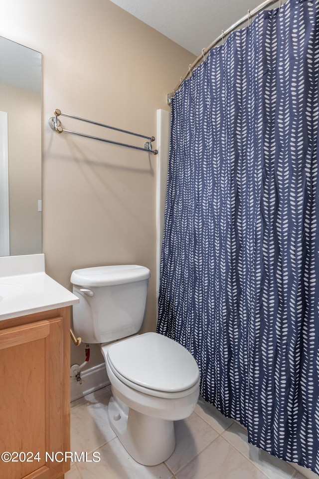 full bathroom with a shower with curtain, baseboards, toilet, vanity, and tile patterned flooring