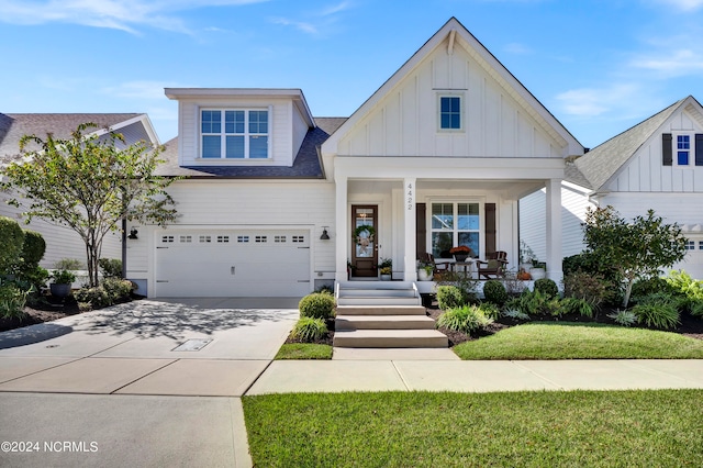 view of front of property with a front yard, a porch, and a garage