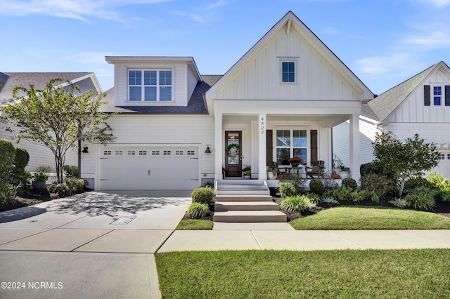 4422 Old Towne St, Wilmington, NC 28412 - view of front of home with driveway, a porch, a garage, a shingled roof, and board and batten siding
