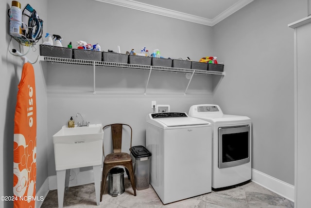 laundry area featuring crown molding and washing machine and clothes dryer