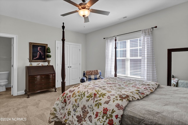 bedroom featuring ensuite bath, light carpet, and ceiling fan