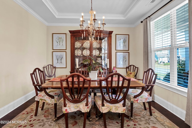 dining space with crown molding, a notable chandelier, a tray ceiling, and dark hardwood / wood-style flooring