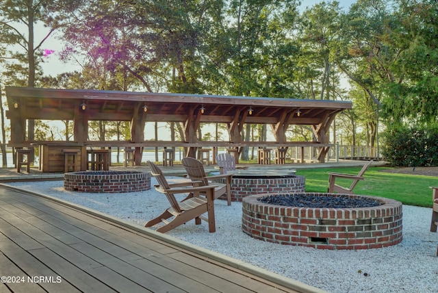 deck featuring a gazebo, a patio, and a fire pit