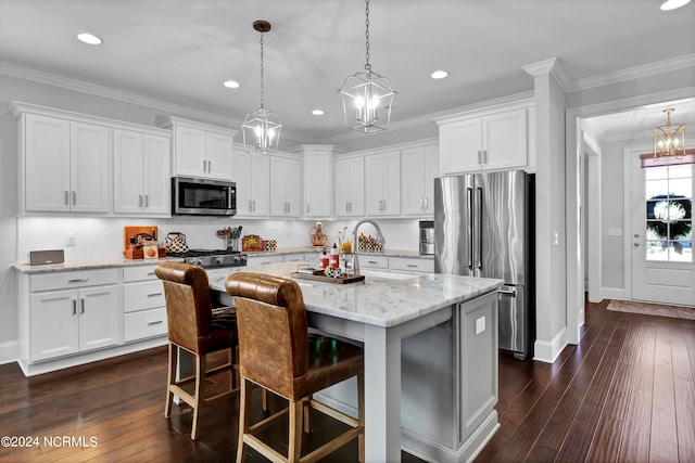 kitchen with appliances with stainless steel finishes, dark wood-type flooring, white cabinets, and a center island with sink