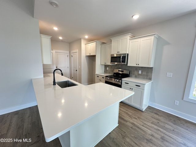 3965 Pepperberry Ln, Southport, NC 28461 - kitchen with appliances with stainless steel finishes, wood finished floors, a peninsula, decorative backsplash, and recessed lighting