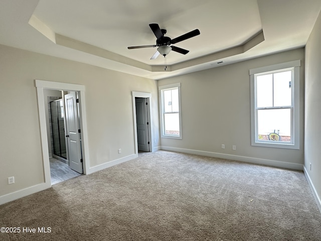 3965 Pepperberry Ln, Southport, NC 28461 - unfurnished bedroom featuring a raised ceiling, carpet flooring, and connected bathroom