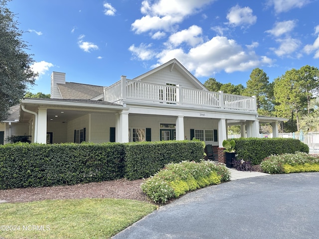 3965 Pepperberry Ln, Southport, NC 28461 - view of side of home with a balcony, a chimney, and a shingled roof