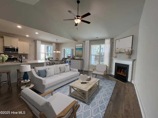 3965 Pepperberry Ln, Southport, NC 28461 - living room featuring vaulted ceiling, a fireplace with flush hearth, dark wood-style floors, recessed lighting, and a ceiling fan