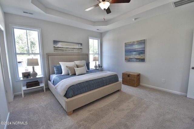 3965 Pepperberry Ln, Southport, NC 28461 - carpeted bedroom with a tray ceiling and ceiling fan