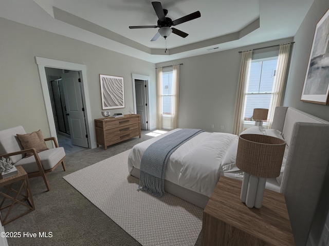 3965 Pepperberry Ln, Southport, NC 28461 - bedroom featuring a raised ceiling, carpet floors, a ceiling fan, and ensuite bath