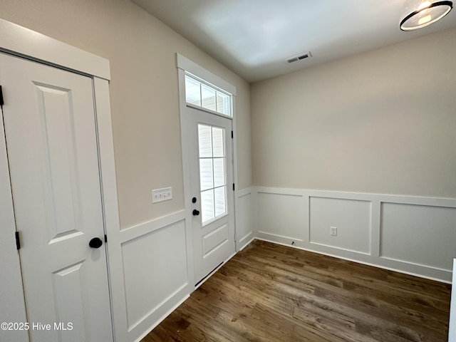 3965 Pepperberry Ln, Southport, NC 28461 - doorway to outside featuring wainscoting and dark wood-style flooring