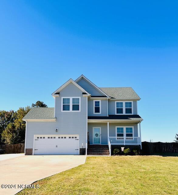 view of front facade featuring a garage, a porch, and a front yard